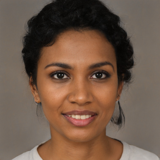 Joyful black young-adult female with short  black hair and brown eyes