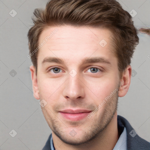 Joyful white young-adult male with short  brown hair and grey eyes