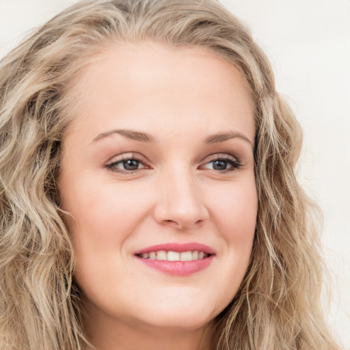 Joyful white young-adult female with long  brown hair and blue eyes