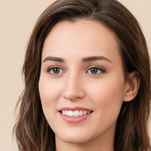 Joyful white young-adult female with long  brown hair and brown eyes