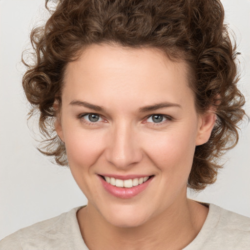 Joyful white young-adult female with medium  brown hair and green eyes