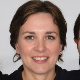 Joyful white adult female with medium  brown hair and grey eyes