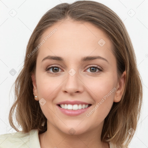 Joyful white young-adult female with long  brown hair and grey eyes