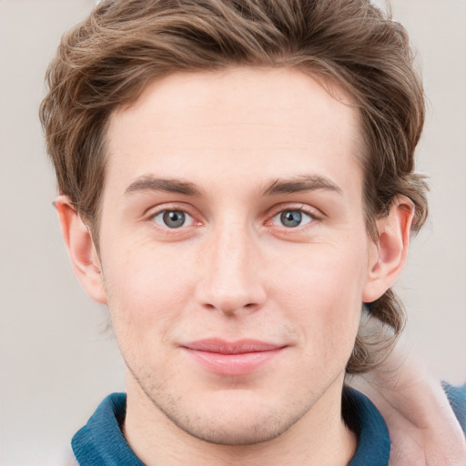 Joyful white young-adult male with short  brown hair and blue eyes