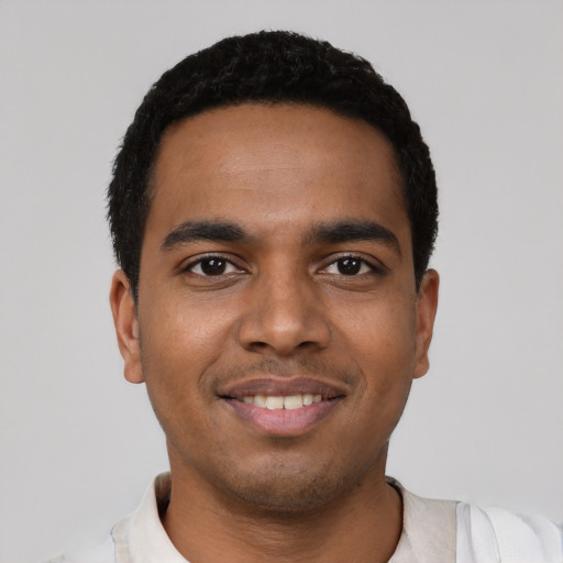 Joyful latino young-adult male with short  black hair and brown eyes