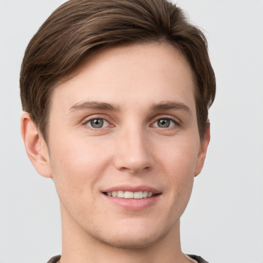 Joyful white young-adult male with short  brown hair and grey eyes