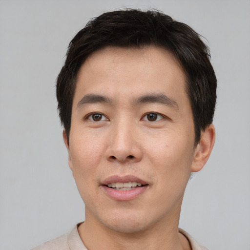 Joyful asian young-adult male with short  brown hair and brown eyes