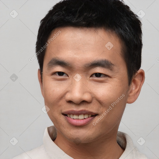 Joyful asian young-adult male with short  black hair and brown eyes