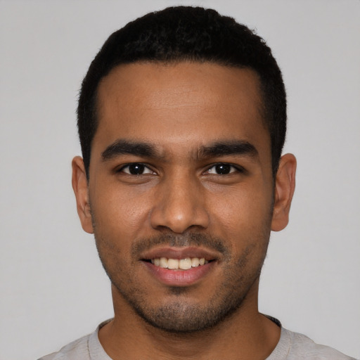 Joyful black young-adult male with short  black hair and brown eyes