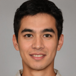 Joyful latino young-adult male with short  brown hair and brown eyes