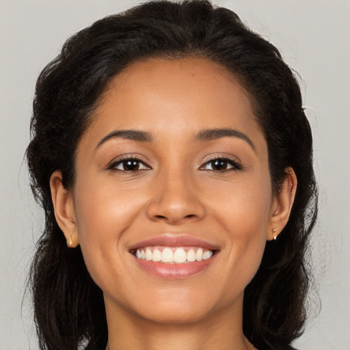 Joyful latino young-adult female with long  brown hair and brown eyes