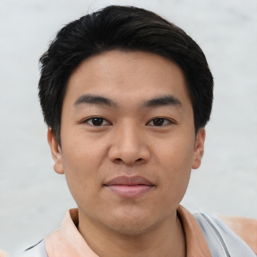Joyful asian young-adult male with short  black hair and brown eyes