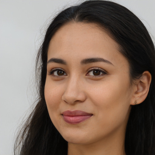 Joyful latino young-adult female with long  brown hair and brown eyes