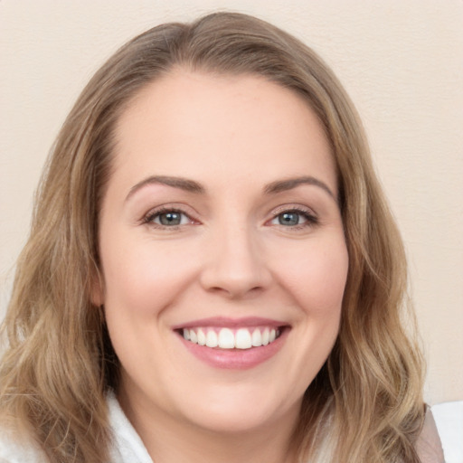 Joyful white young-adult female with long  brown hair and green eyes