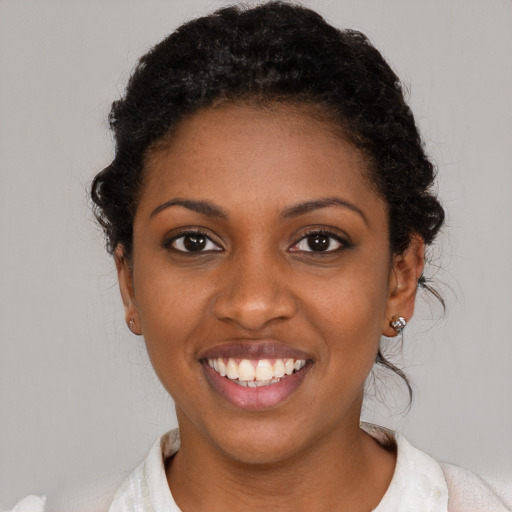 Joyful black young-adult female with short  black hair and brown eyes