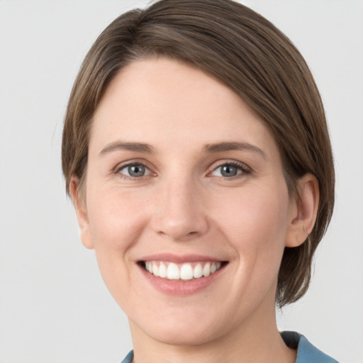 Joyful white young-adult female with medium  brown hair and grey eyes