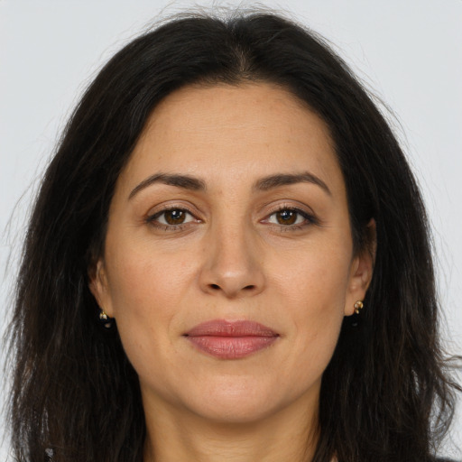 Joyful latino adult female with long  brown hair and brown eyes