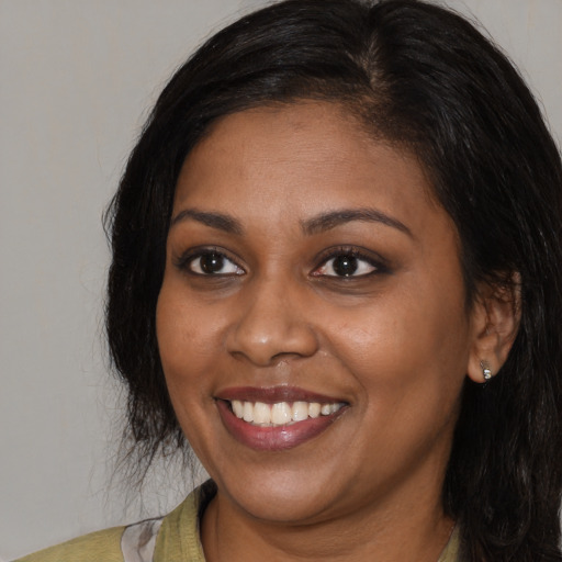 Joyful black young-adult female with medium  black hair and brown eyes