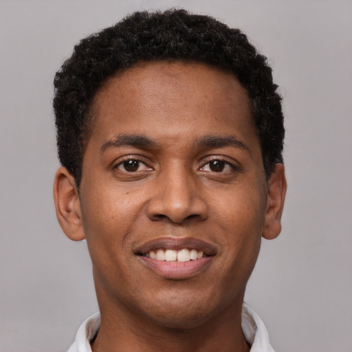 Joyful black young-adult male with short  brown hair and brown eyes