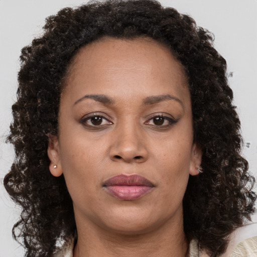 Joyful black adult female with medium  brown hair and brown eyes