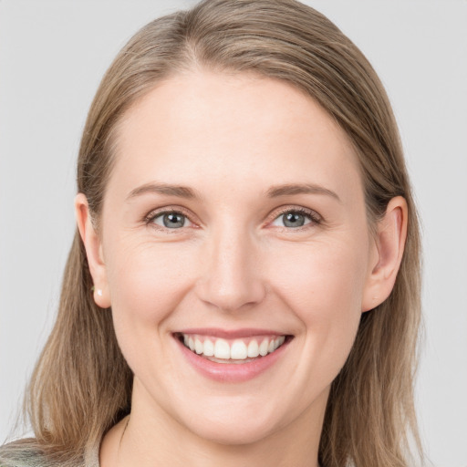 Joyful white young-adult female with long  brown hair and blue eyes