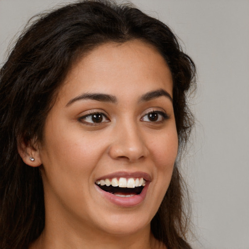 Joyful latino young-adult female with long  brown hair and brown eyes