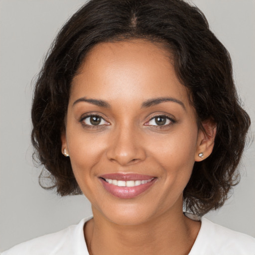 Joyful black young-adult female with medium  brown hair and brown eyes