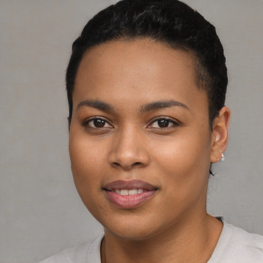 Joyful black young-adult female with short  black hair and brown eyes
