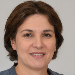 Joyful white adult female with medium  brown hair and grey eyes