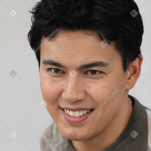 Joyful asian young-adult male with short  brown hair and brown eyes