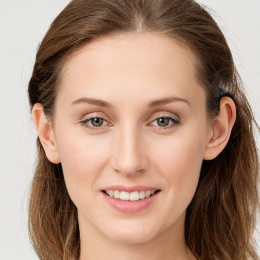 Joyful white young-adult female with long  brown hair and blue eyes