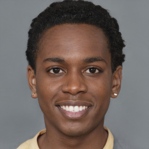Joyful black young-adult male with short  brown hair and brown eyes