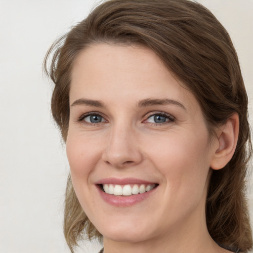 Joyful white young-adult female with medium  brown hair and grey eyes