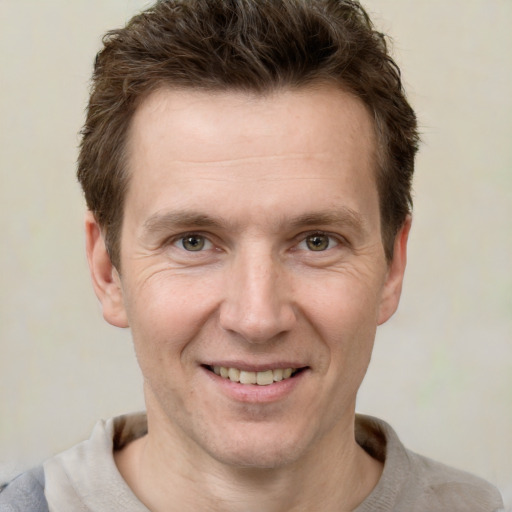 Joyful white adult male with short  brown hair and grey eyes