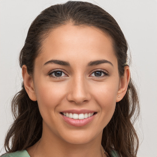 Joyful white young-adult female with long  brown hair and brown eyes