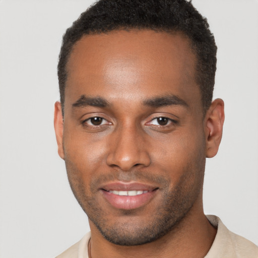 Joyful black young-adult male with short  brown hair and brown eyes