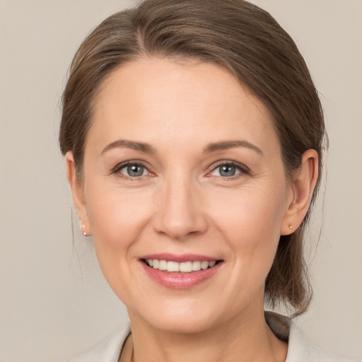 Joyful white adult female with medium  brown hair and grey eyes