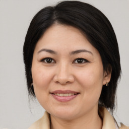 Joyful asian adult female with medium  brown hair and brown eyes