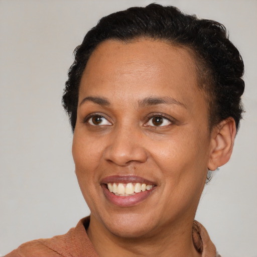 Joyful black adult female with short  brown hair and brown eyes