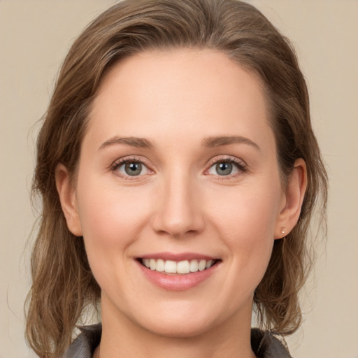 Joyful white young-adult female with medium  brown hair and grey eyes