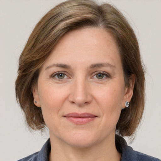 Joyful white adult female with medium  brown hair and grey eyes