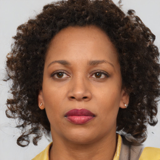 Joyful black adult female with medium  brown hair and brown eyes
