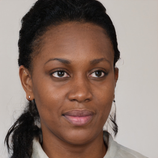 Joyful black young-adult female with short  brown hair and brown eyes
