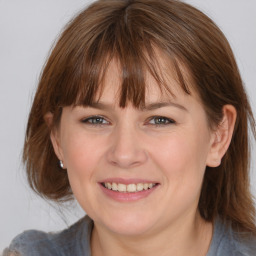 Joyful white young-adult female with medium  brown hair and blue eyes