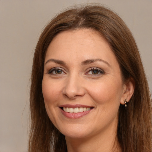 Joyful white adult female with long  brown hair and brown eyes