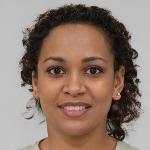 Joyful black young-adult female with medium  brown hair and brown eyes
