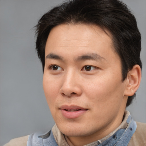 Joyful asian young-adult male with short  brown hair and brown eyes