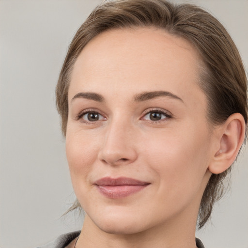 Joyful white young-adult female with medium  brown hair and grey eyes