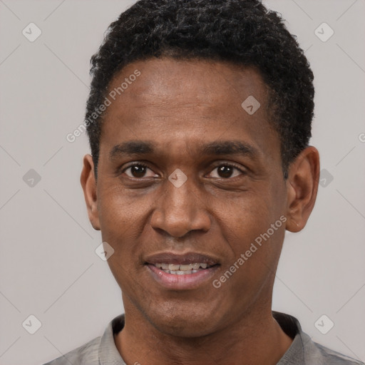 Joyful black adult male with short  black hair and brown eyes