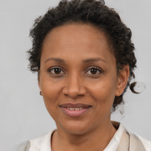 Joyful black adult female with short  brown hair and brown eyes